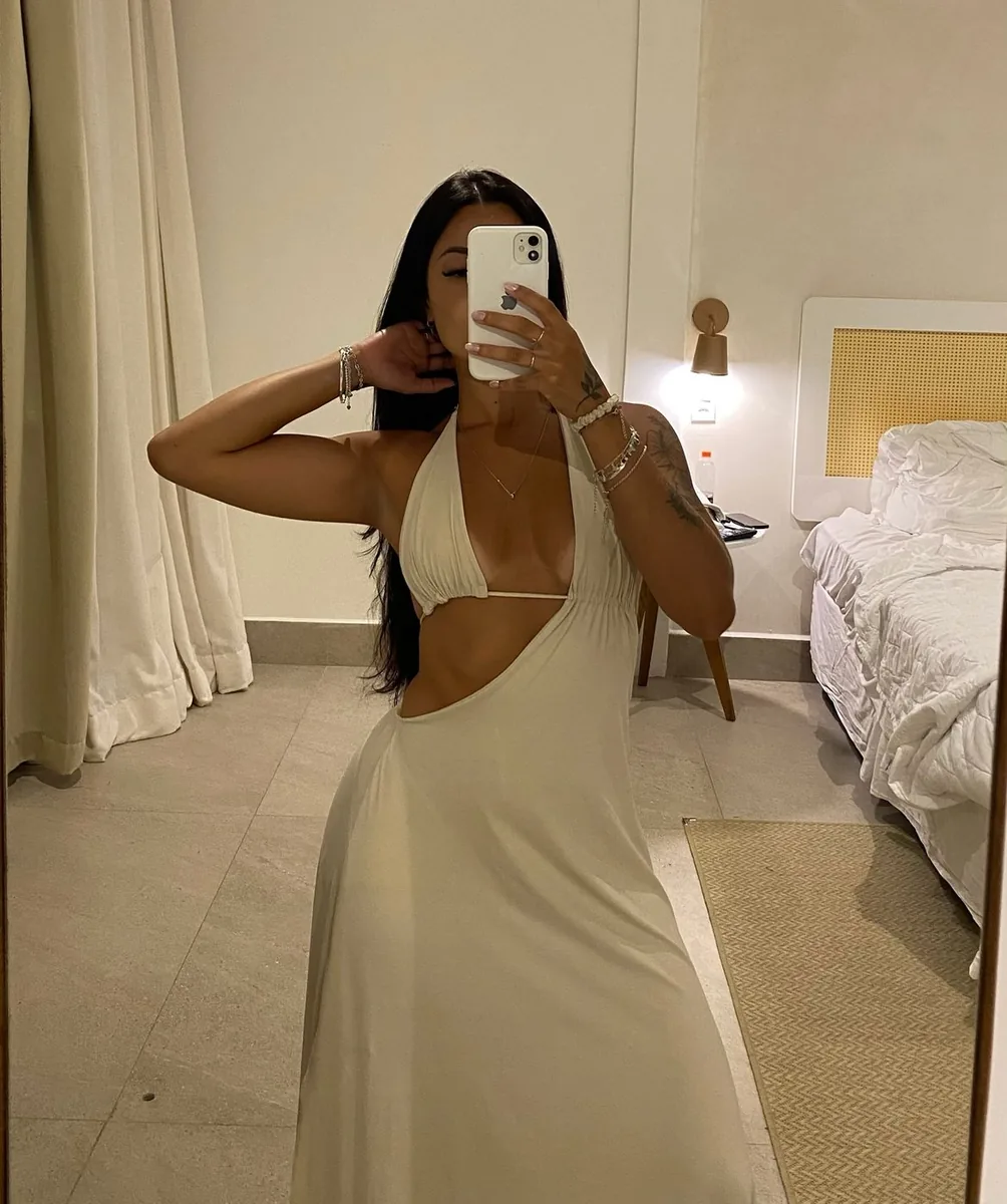 Kamila Costa em vestido branco durante viagem